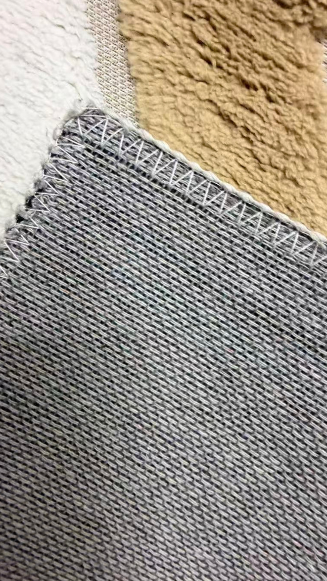 Alfombra geométrica beige y marfil en un living con sofá crema y mesa de centro dorada